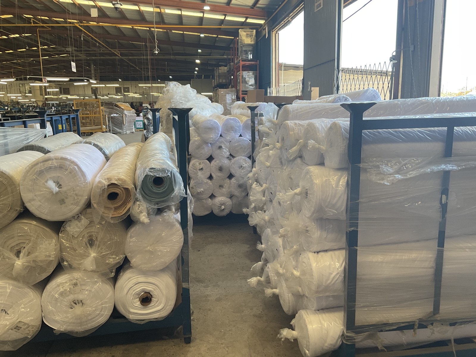 Fabric roll inventory staged in the warehouse for production