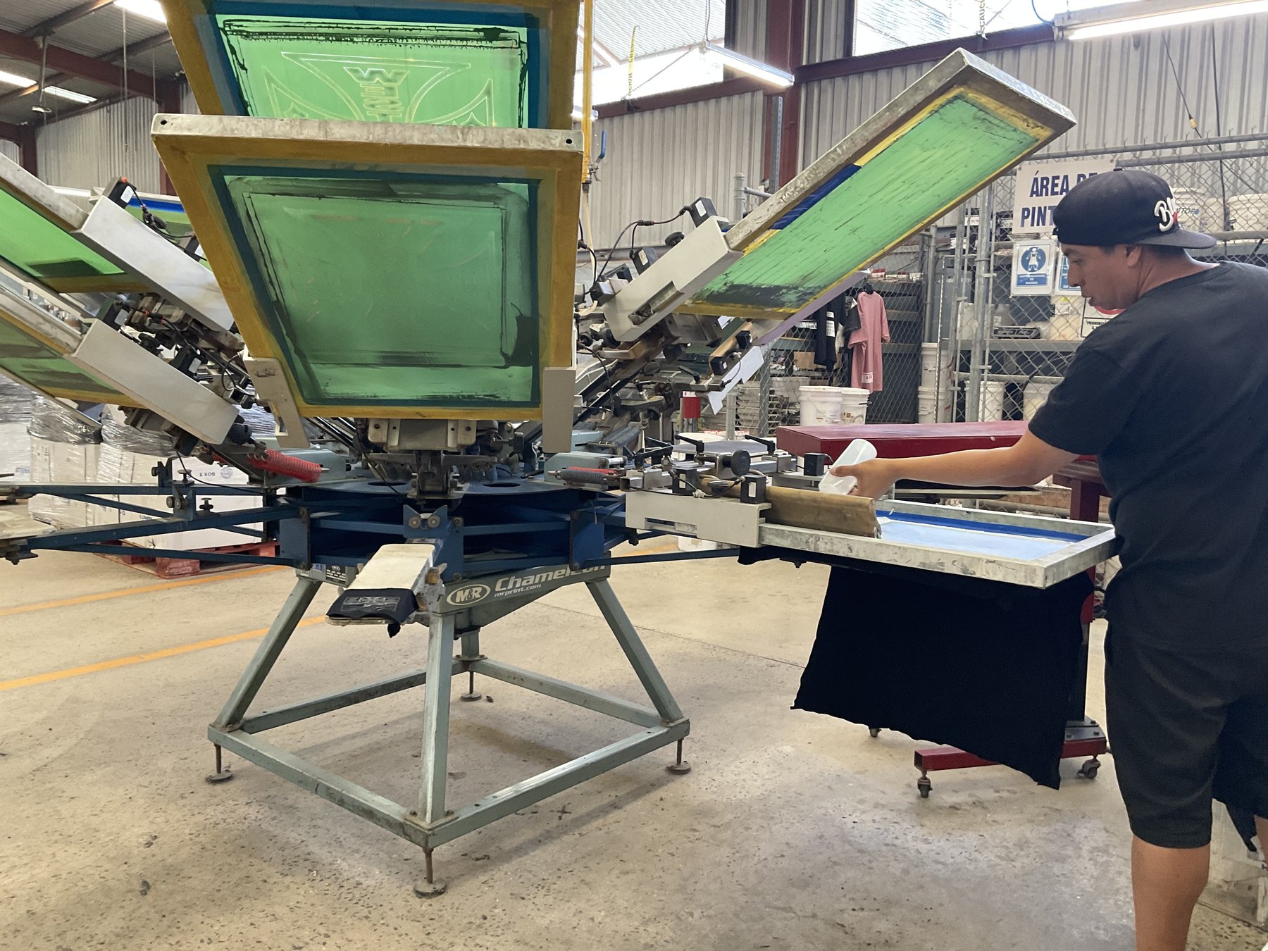 Manual screen printing station finishing a dark shirt